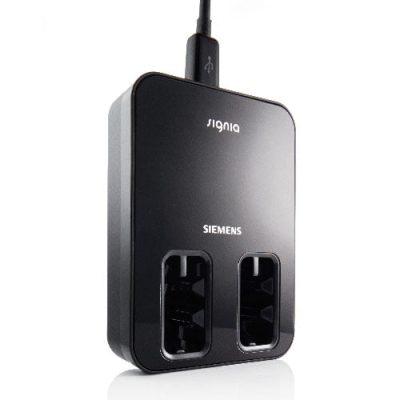 The Signia Inductive Charger E is a black hearing aid charger featuring two charging slots and a USB cable connected at the top.