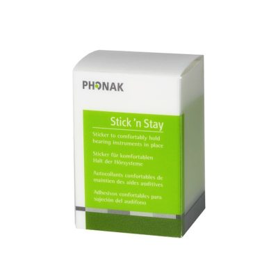 A box of Phonak Stick'n Stay is featured with green and white packaging and multilingual text, showing its purpose to comfortably secure hearing instruments.