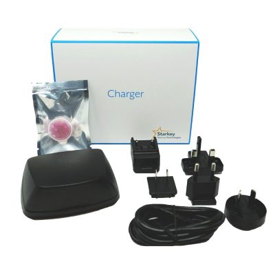 A Starkey Standard Charger set includes a white Charger box, black charging case, plug adapters, power cord, USB plug, and a sealed pink cleaning tablet.